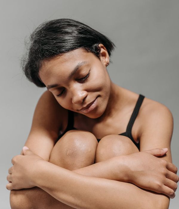 Person sitting peacefully with eyes closed, embodying a sense of calm and well-being.
